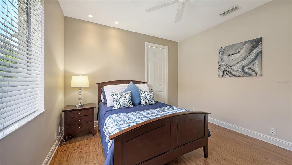 6919 Dominion Lane Lakewood Ranch, FL 34202 - Photo 50 of 99 a living room with a bed and a wooden floor