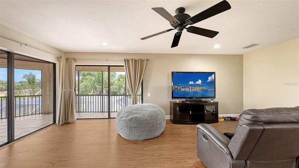 6919 Dominion Lane Lakewood Ranch, FL 34202 - Photo 60 of 99 a living room with furniture and a flat screen tv