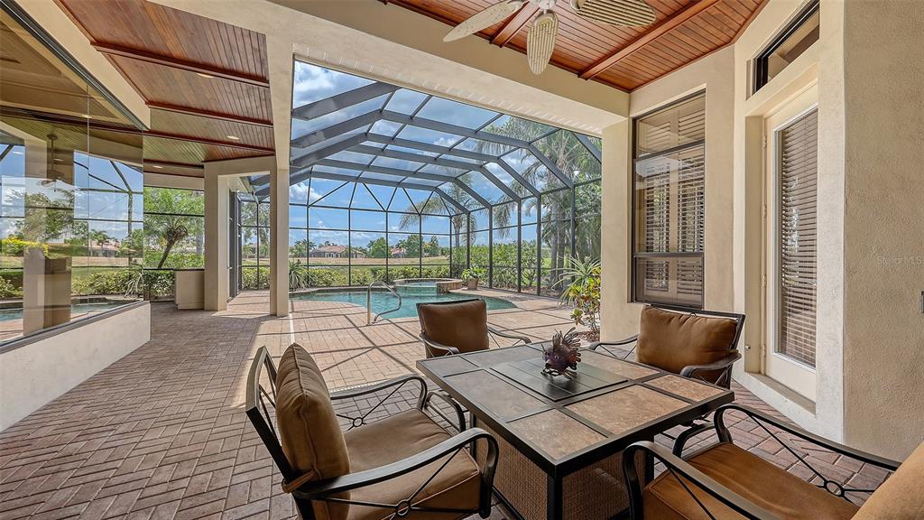 6919 Dominion Lane Lakewood Ranch, FL 34202 - Photo 70 of 99 a outdoor dining space with furniture and wooden floor