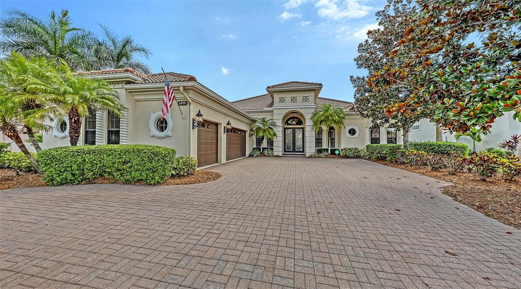 6919 Dominion Lane Lakewood Ranch, FL 34202 - Photo 97 of 99 a front view of a house with a yard and garage