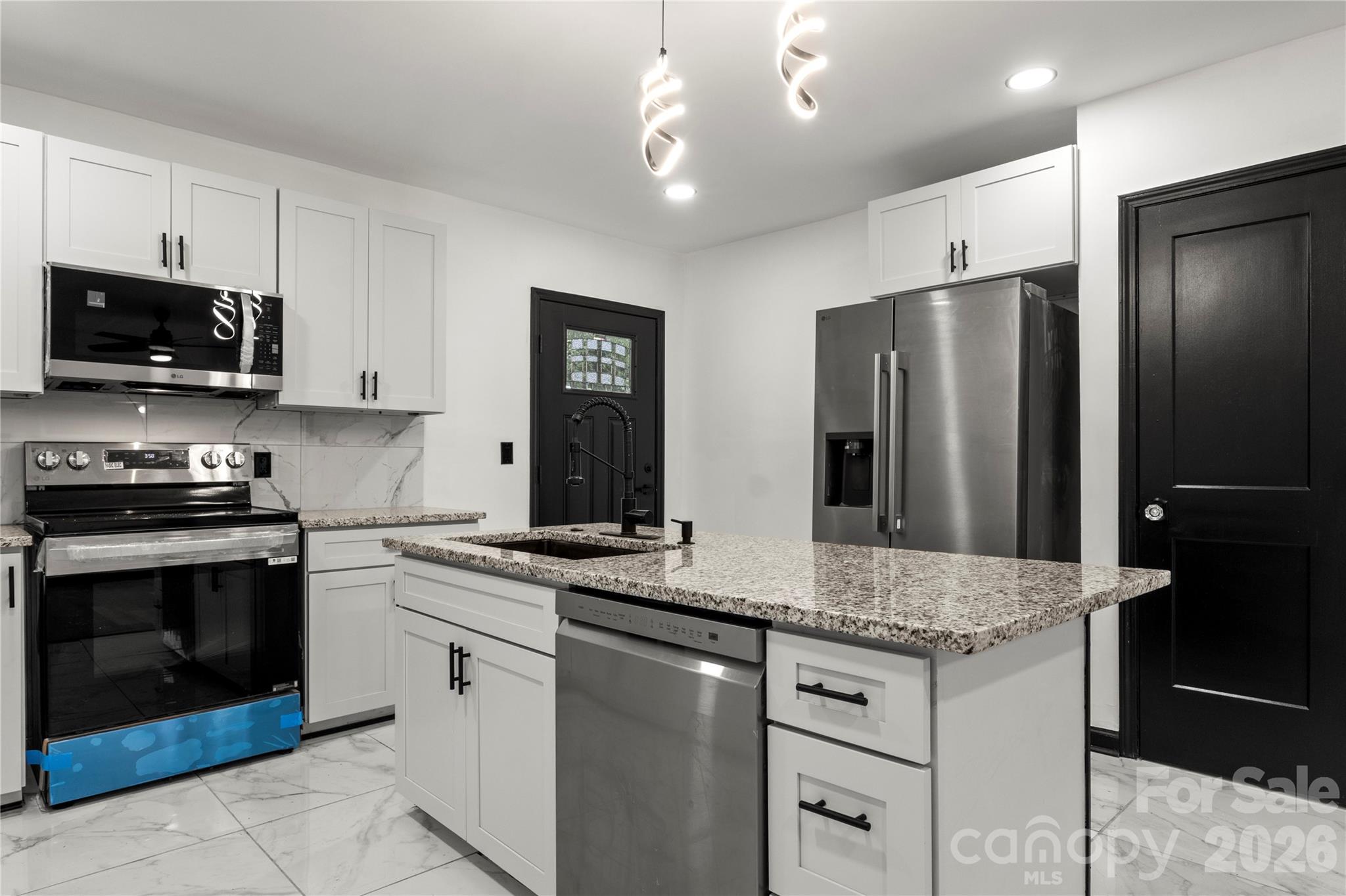 110 Courtland Street Chester, SC 29706 - Photo 7 of 22 a kitchen with stainless steel appliances granite countertop a stove refrigerator and microwave