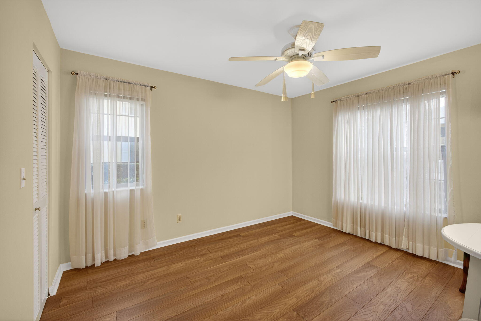 2041 Keystone Drive, Unit F Jupiter, FL 33458 - Photo 31 of 63 an empty room with wooden floor fan and windows