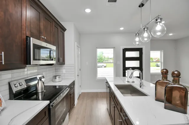 a kitchen with stove a sink and refrigerator