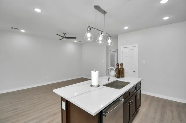 a kitchen with a sink cabinets and wooden floor