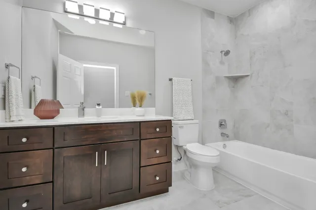 a bathroom with a tub a sink double vanity and mirror