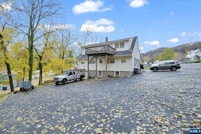 a view of a house with a yard and parking