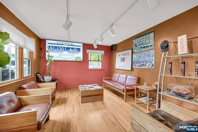 a living room with furniture a flat screen tv and a floor to ceiling window