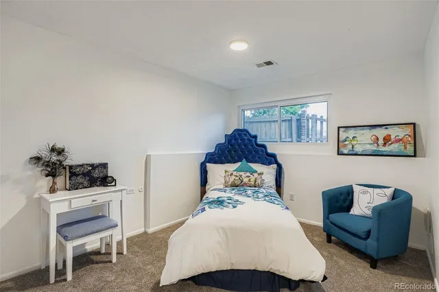 a bedroom with a bed a rug and a chair