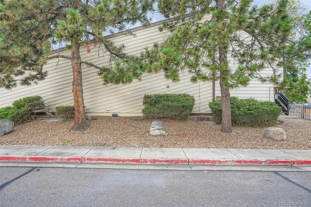 a white house with a yard and large trees