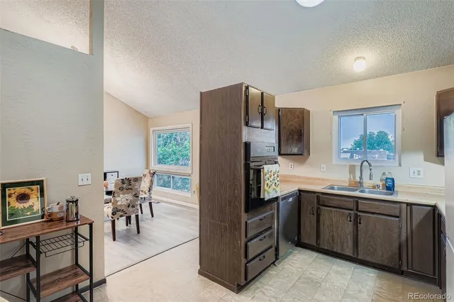 a kitchen with stainless steel appliances a sink cabinets and wooden floor