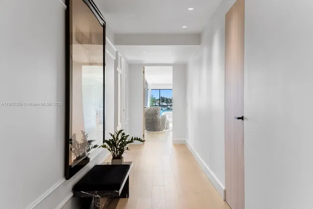 a hallway with a potted plant on the table and a chair