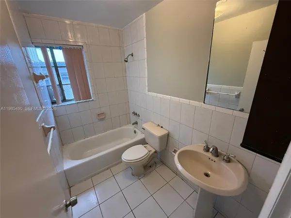 a kitchen with a sink a refrigerator and cabinets