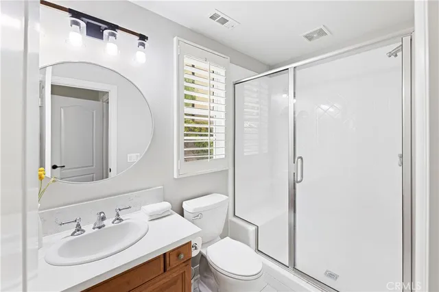 a bathroom with a shower sink and mirror