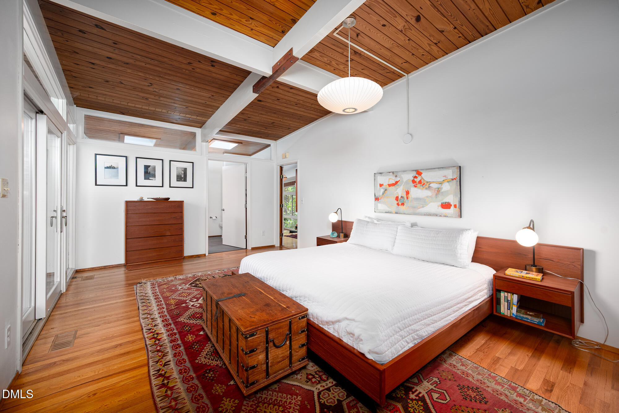 1030 Highland Woods Road Chapel Hill, NC 27517 - Photo 25 of 64 a bedroom with a bed and a chandelier