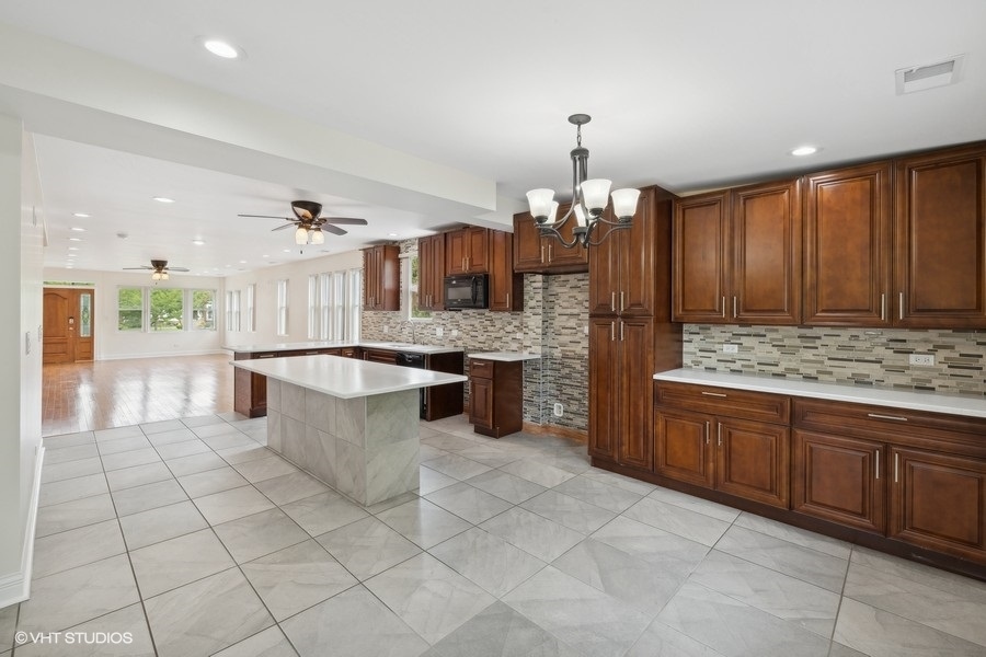 369 Blackhawk Road Riverside, IL 60546 - Photo 10 of 31 a large kitchen with kitchen island a counter a stove a sink and a refrigerator