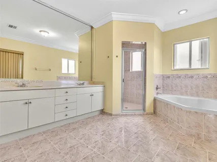 a spacious bathroom with a granite countertop sink a mirror a bathtub and