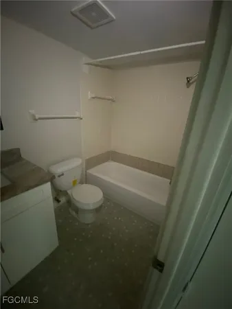 a bathroom with a granite countertop toilet and a sink