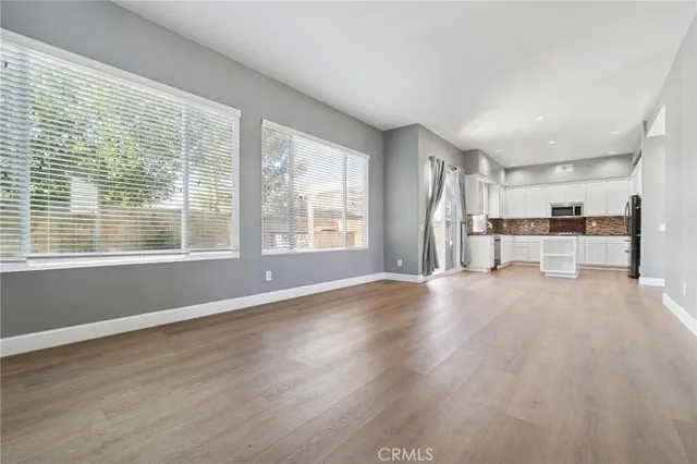 a view of empty room with wooden floor and window