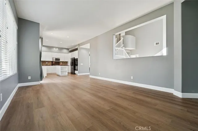 a view of a room with wooden floor and a window
