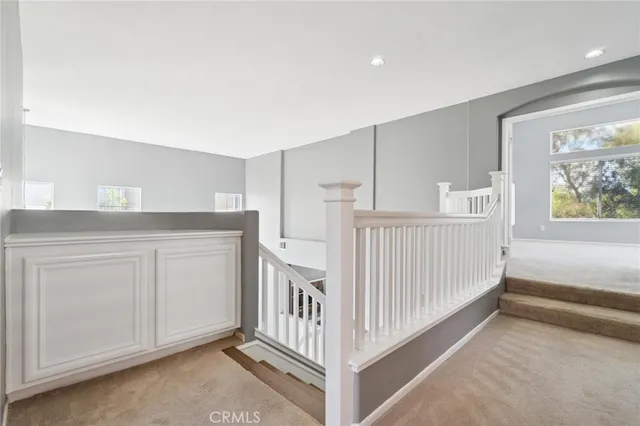 an empty room with windows and fireplace