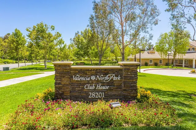 a view of a swimming pool with table and chairs under an umbrella