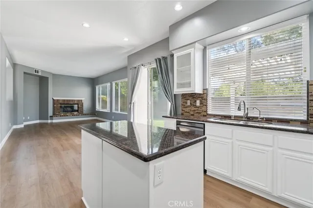 a kitchen with granite countertop a sink and a refrigerator