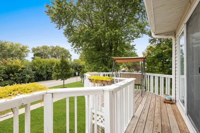 a view of a balcony with wooden floor and fence