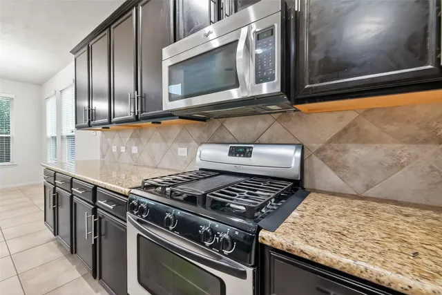 a large kitchen with stainless steel appliances and a stove top oven