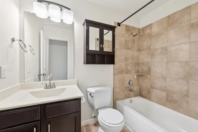 a bathroom with a sink a toilet a mirror a vanity and bathtub