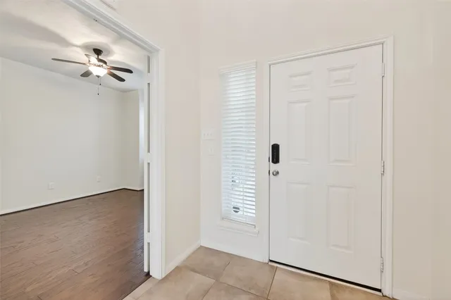 a view of empty room with kitchen and fireplace