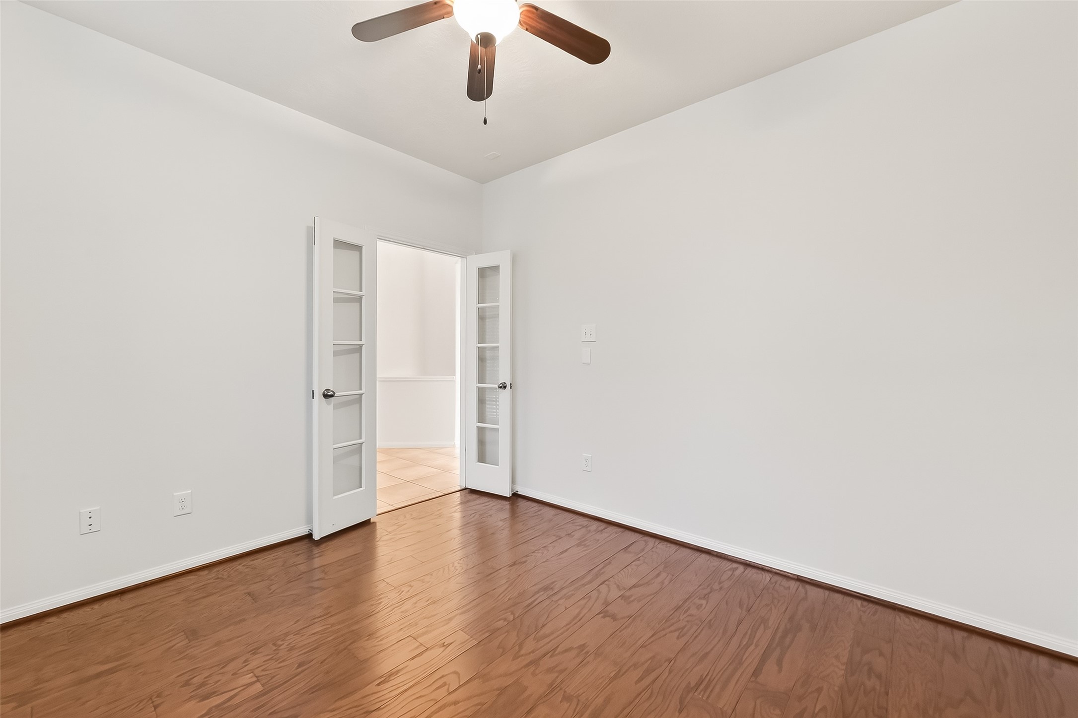 25018 Clover Ranch Drive Katy, TX 77494 - Photo 10 of 45 an empty room with a ceiling fan and wooden floor