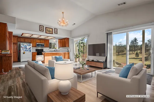a view of a livingroom with wooden floor and a ceiling fan