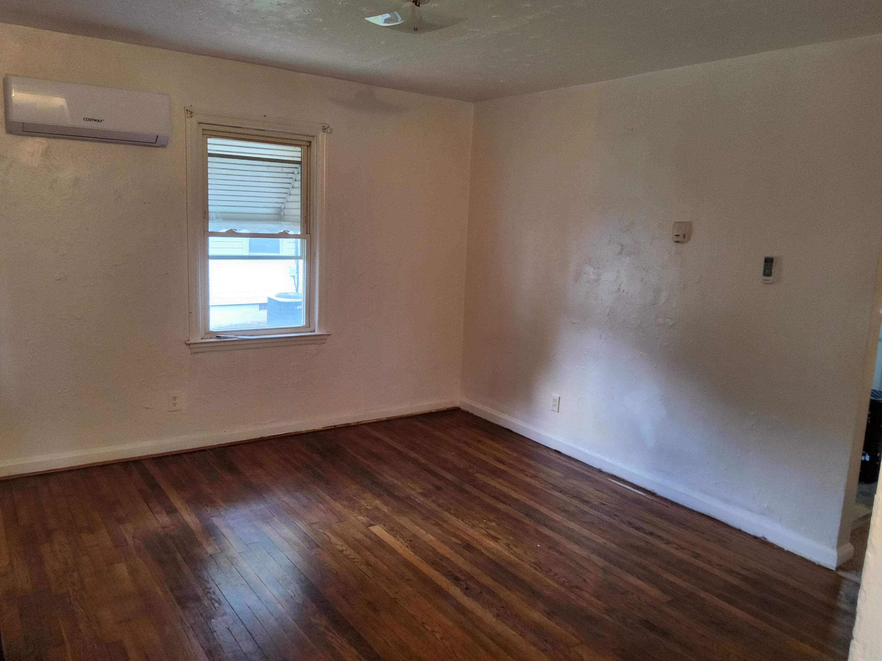 4935 Fralin Road Northwest Roanoke, VA 24012 - Photo 4 of 16 a view of an empty room with wooden floor and a window