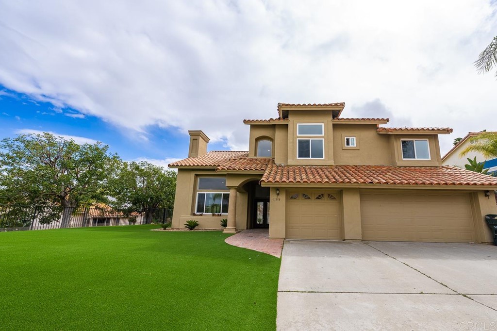 a front view of a house with a garden and yard