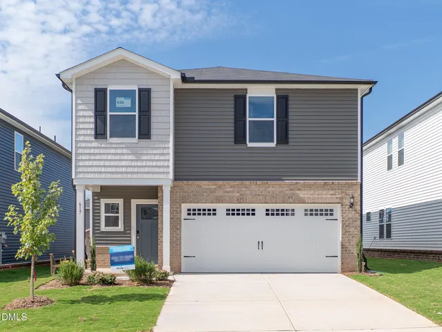a view of a house with a yard and potted plants