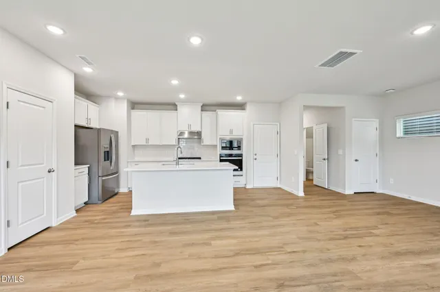 a large kitchen with kitchen island a sink stainless steel appliances and cabinets