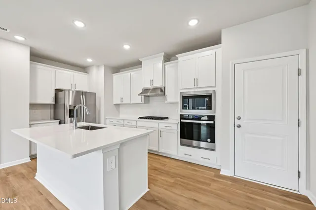 a kitchen with a sink a stove top oven and refrigerator