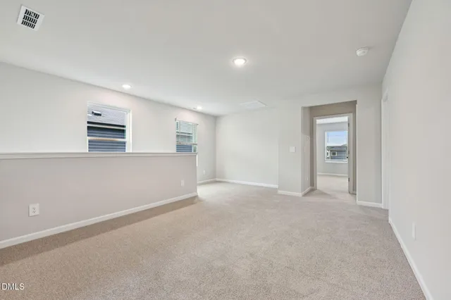 an empty room with windows and cabinet