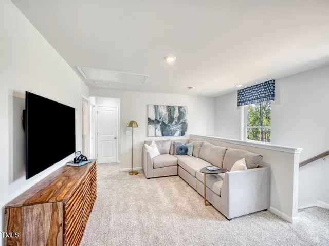 a living room with furniture a flat screen tv and a large window
