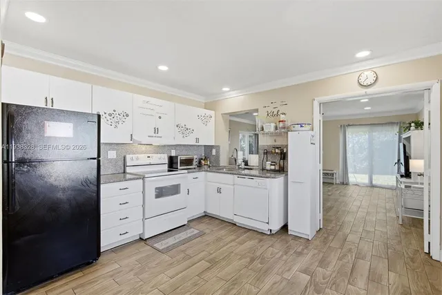 a kitchen with white cabinets and white appliances