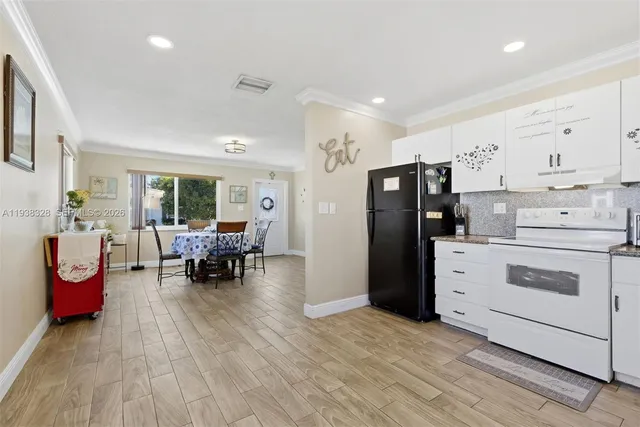 a kitchen that has a lot of cabinets a sink and wooden floor