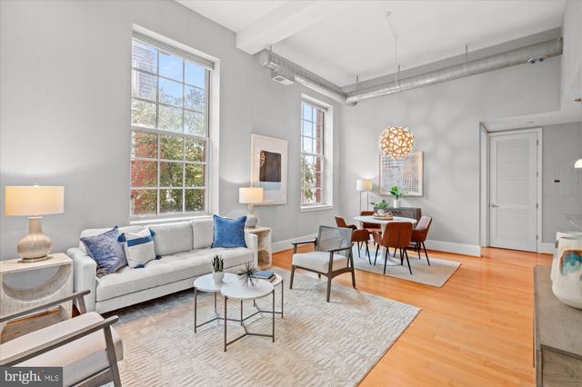 a living room with furniture a dining table and a window