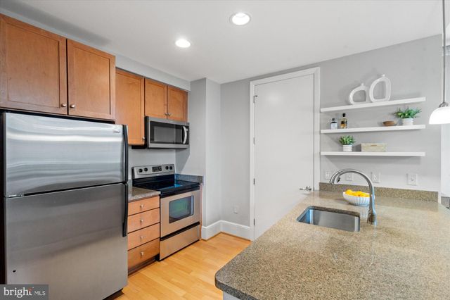 a kitchen with granite countertop stainless steel appliances and wooden cabinets