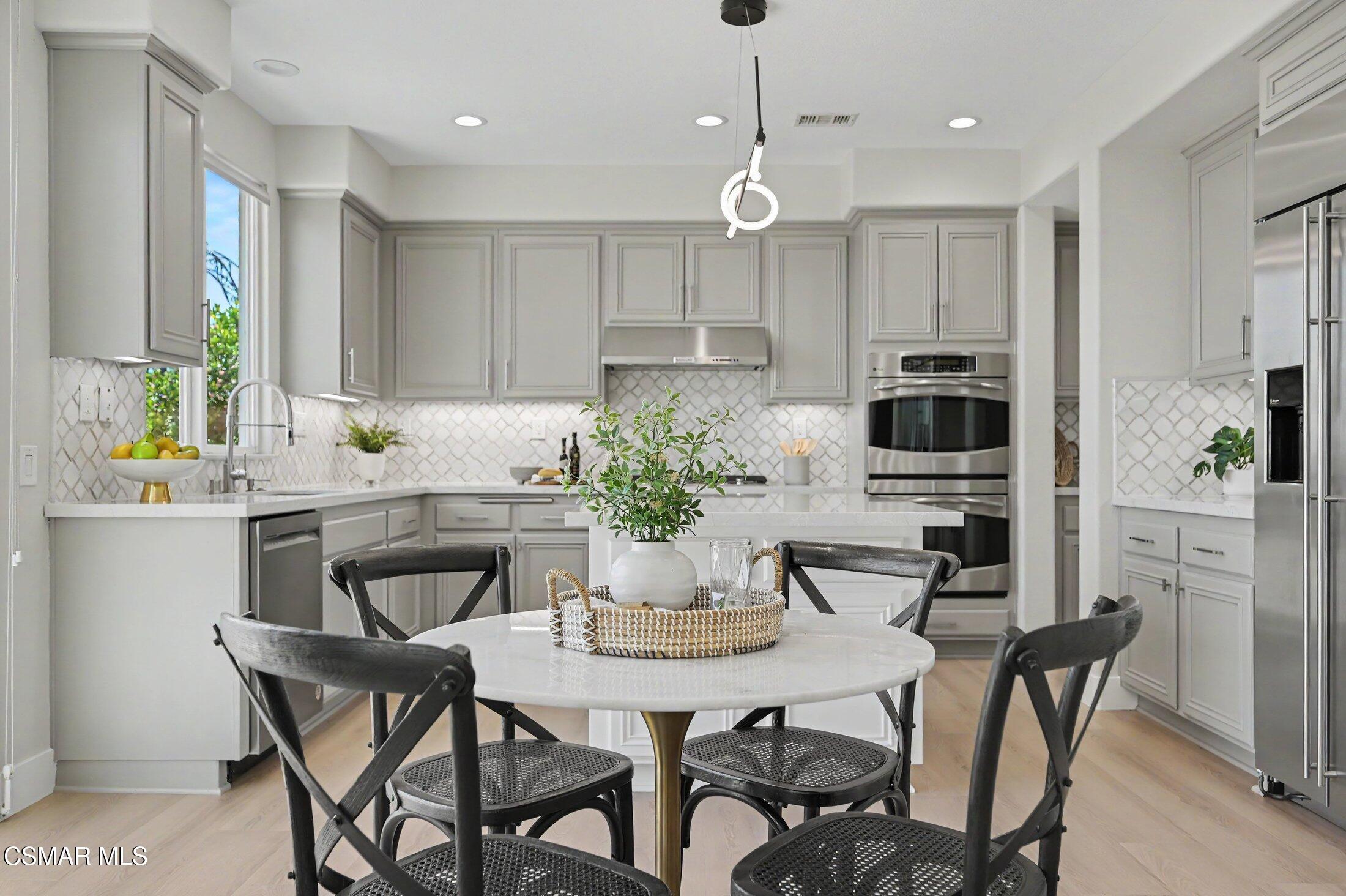 20800 Sardinia Way Porter Ranch, CA 91326 - Photo 16 of 57 a kitchen with a table and chairs in it
