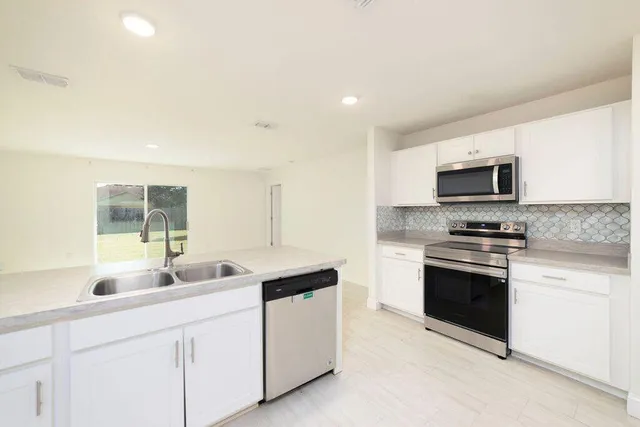 a kitchen with stainless steel appliances granite countertop a sink and a microwave