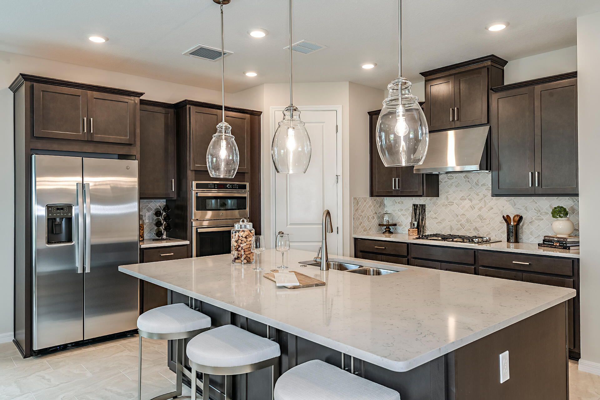 593 Southeast Ranch Oak Circle Port St. Lucie, FL 34984 - Photo 3 of 35 a kitchen with stainless steel appliances granite countertop a sink a stove a refrigerator and island