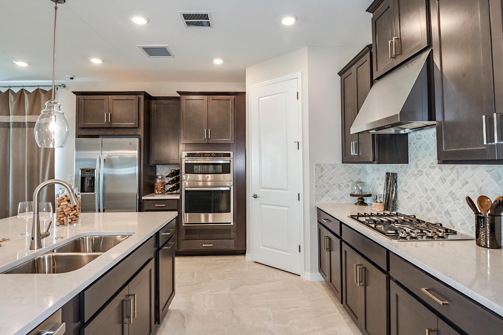593 Southeast Ranch Oak Circle Port St. Lucie, FL 34984 - Photo 4 of 35 a kitchen with kitchen island granite countertop a sink stainless steel appliances and counter space