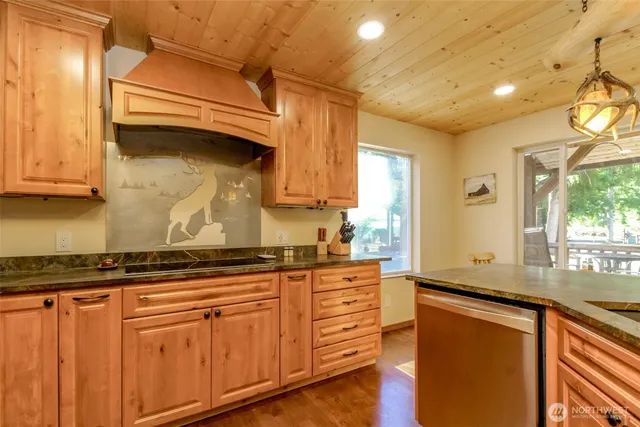 a kitchen with stainless steel appliances granite countertop a sink a stove and a wooden floors