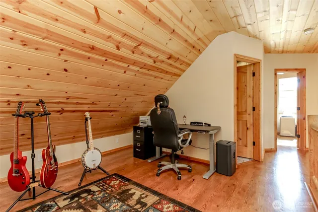 a view of a hallway with wooden floor and furniture