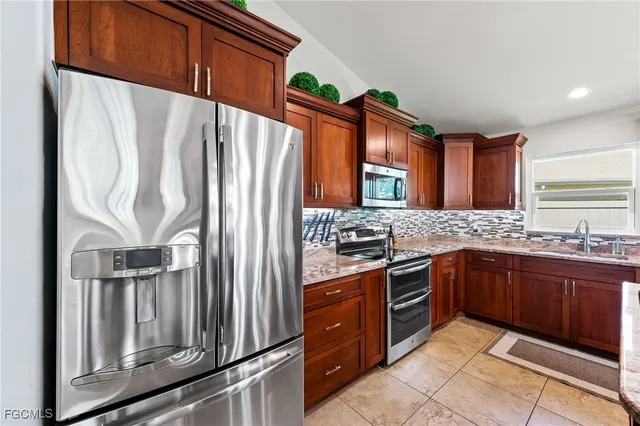a kitchen with stainless steel appliances granite countertop a refrigerator and a stove top oven